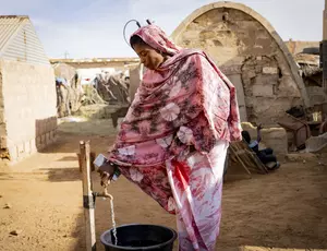 Une femme à une borne fontaine