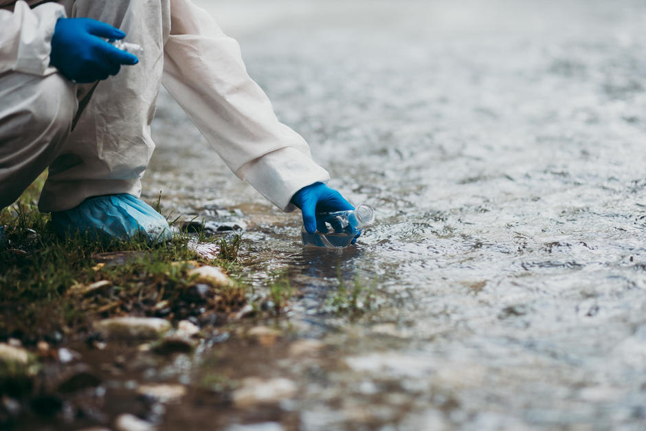 Scientist in protective suite taking water samples from the river / Photo © hedgehog94/Adobe Stock