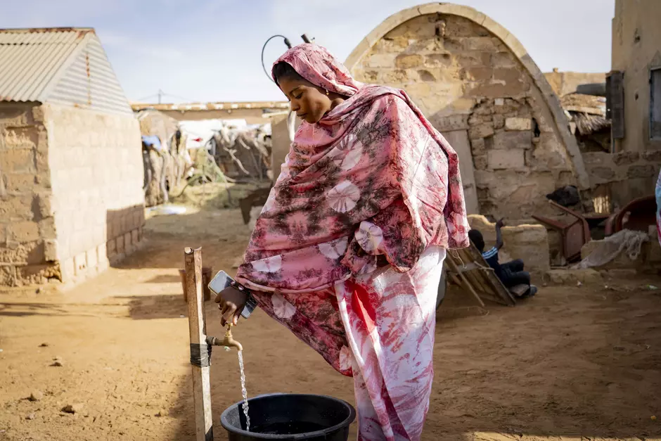 Une femme à une borne fontaine